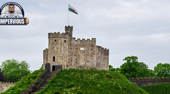 News - Historic stone castle in Wales on a grassy hill under cloudy skies, illustrating exposure to moisture and the need for effective waterproofing